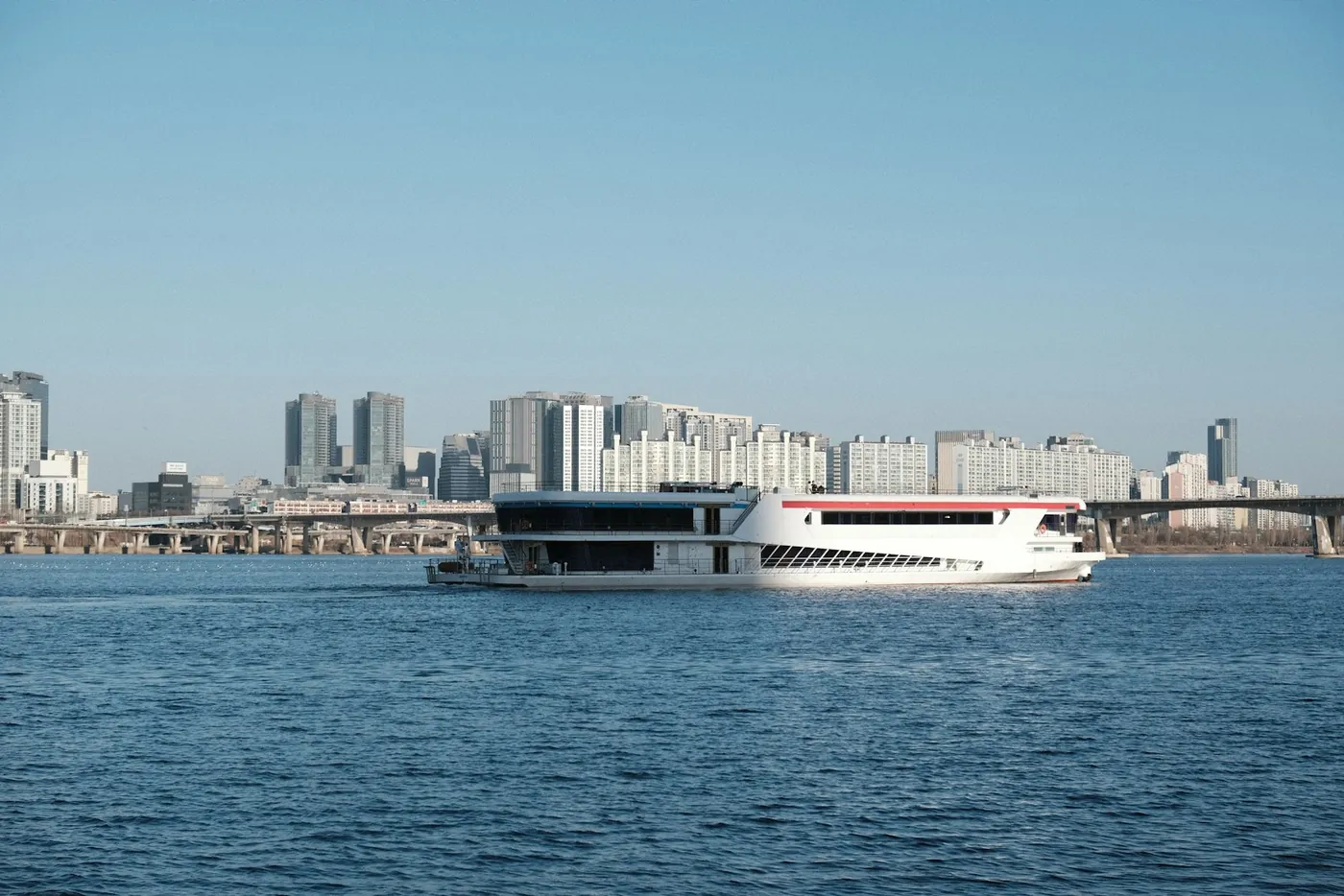 A sightseeing boat on the Han River with the Seoul skyline behind it, South Korea