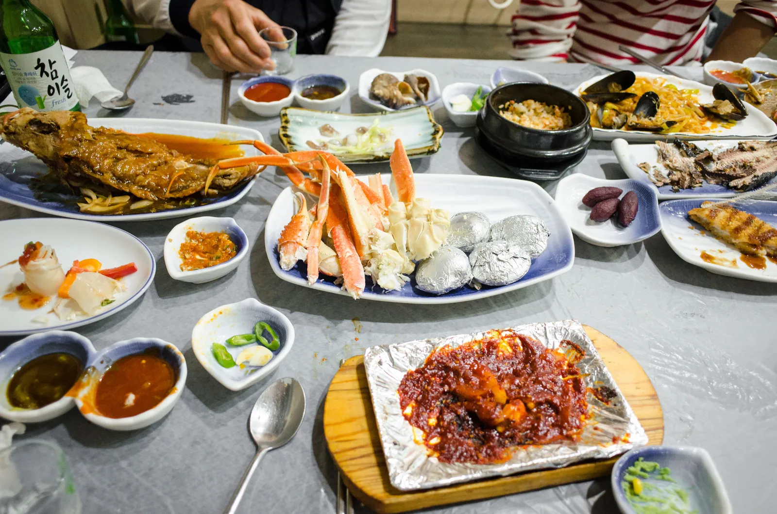 A table crowded with seafood dishes and banchan side dishes, South Korea