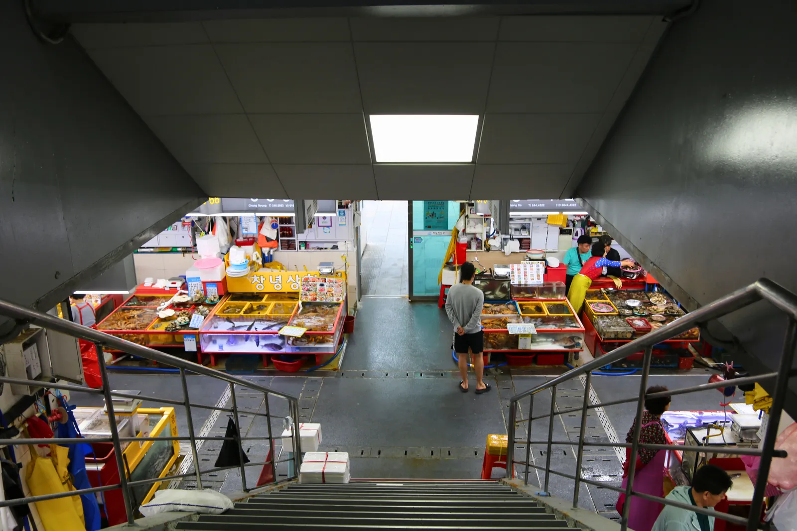 A stairway down into the stalls of a covered market hall in Busan, South Korea