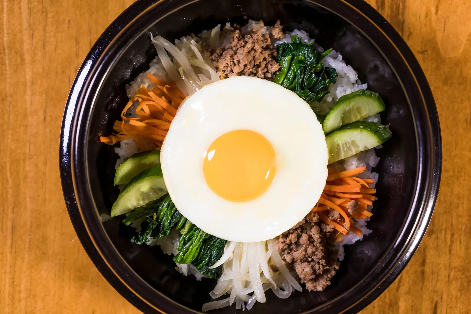 A bowl of bibimbap with vegetables and a fried egg on top, South Korea