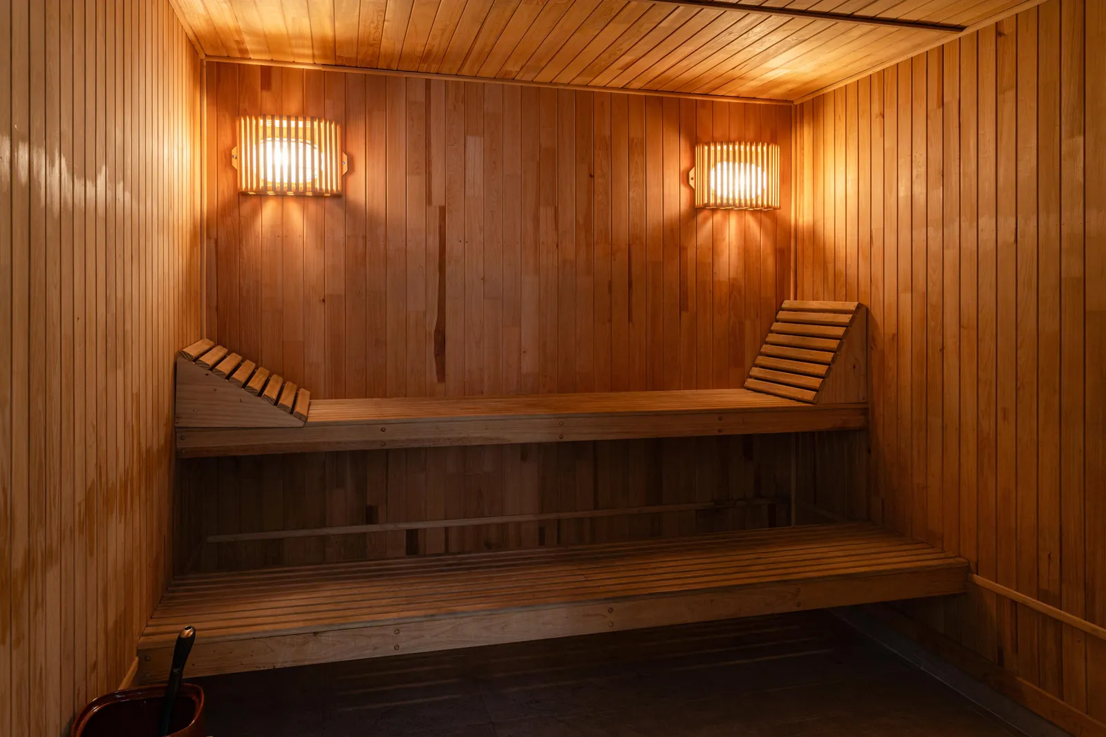 The wooden interior of a dry sauna room with benches and wall lights, South Korea