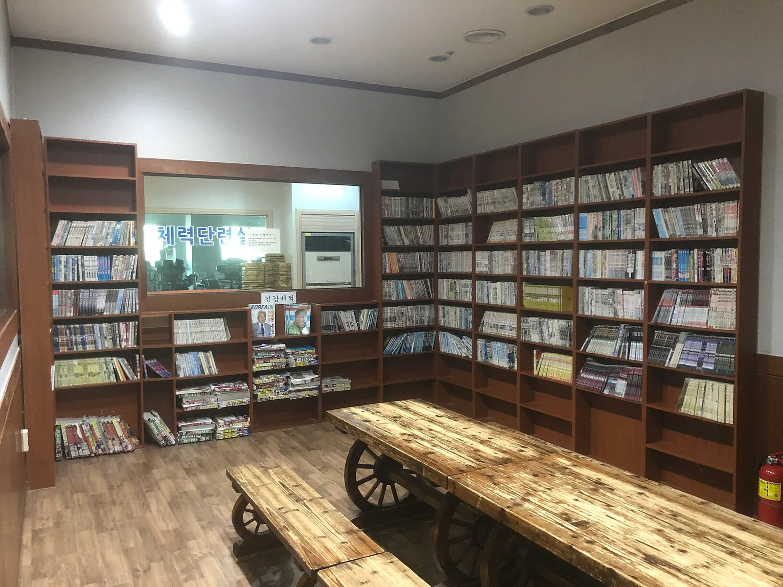 The reading room of a Korean bathhouse complex with bookshelves and low tables, South Korea