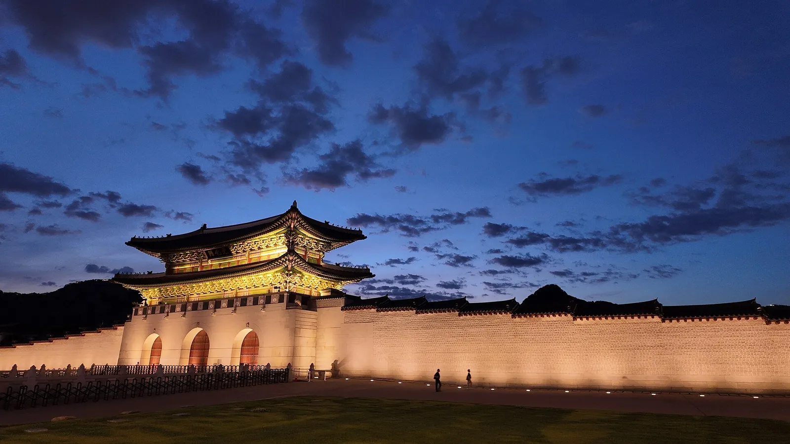 Gyeongbokgung Palace lit up against a deep blue sky at dusk in Seoul, South Korea