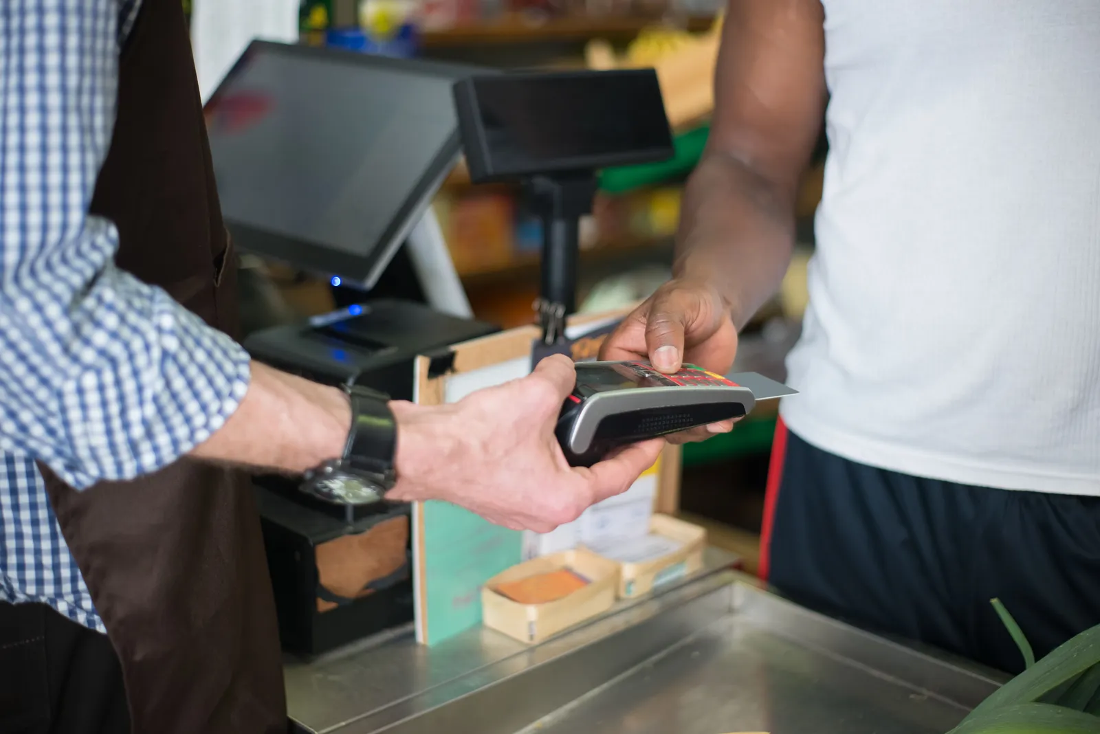A customer paying by contactless card at a shop counter in South Korea