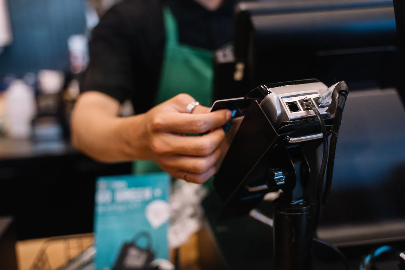 A card being tapped on a payment terminal at a cafe counter in South Korea