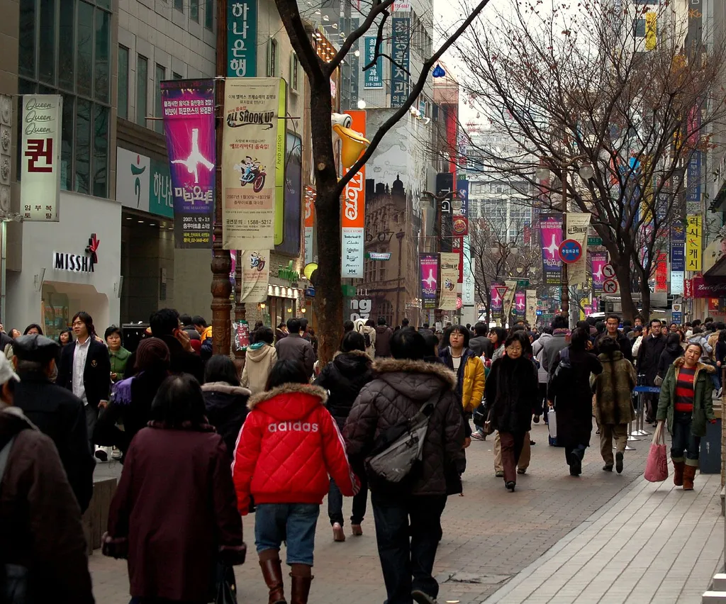 A busy shopping street in central Seoul with crowds of pedestrians in South Korea