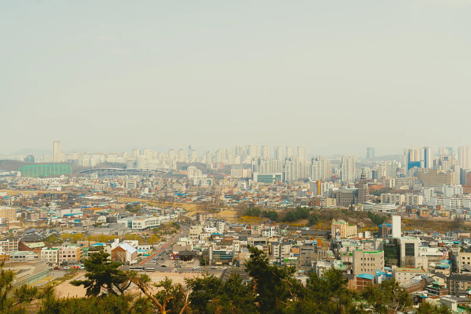 A view over central Seoul from an elevated viewpoint showing dense streets and subway lines below, South Korea