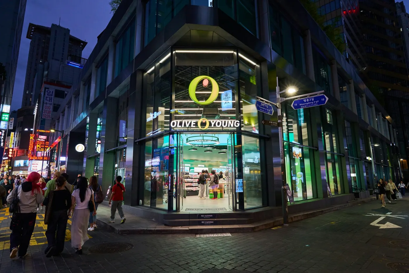 Shop signs and shoppers in the Myeongdong shopping district of Seoul at night