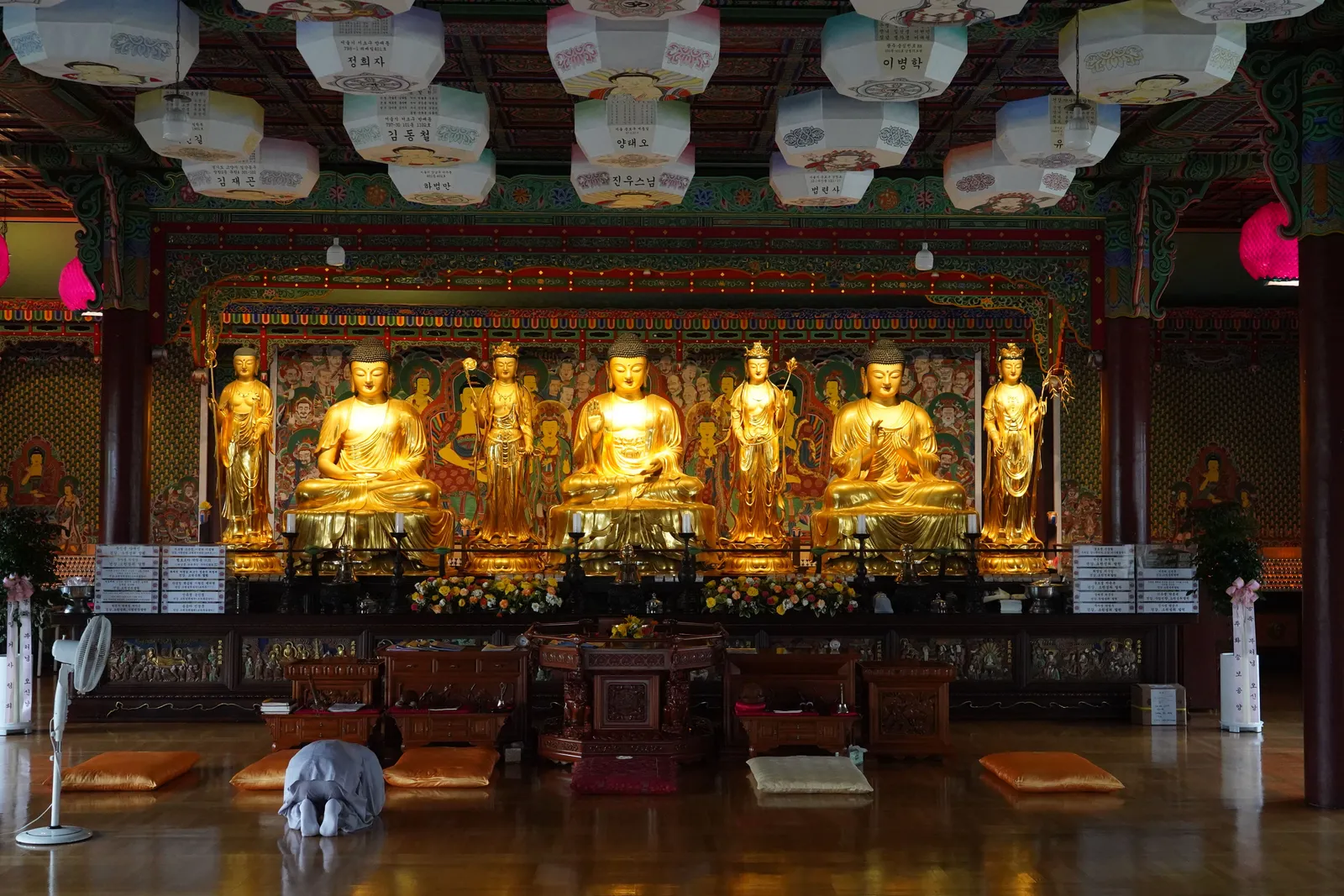 The interior of a Korean Buddhist temple hall with cushions laid out for meditation