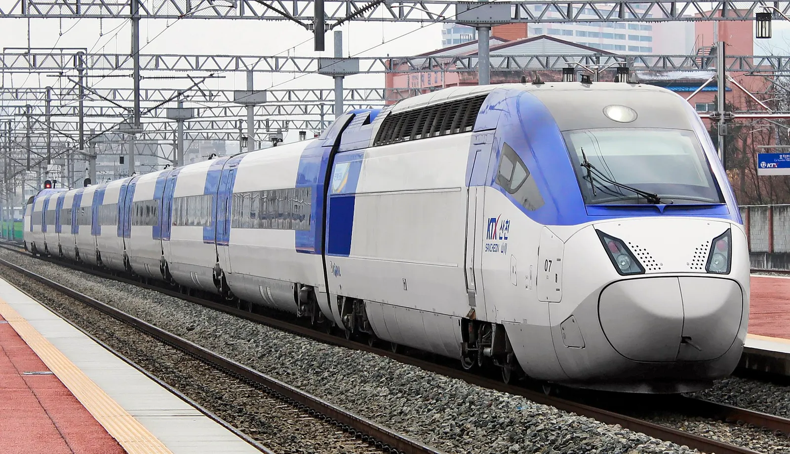 A sleek white KTX high-speed train waiting at a station platform in South Korea