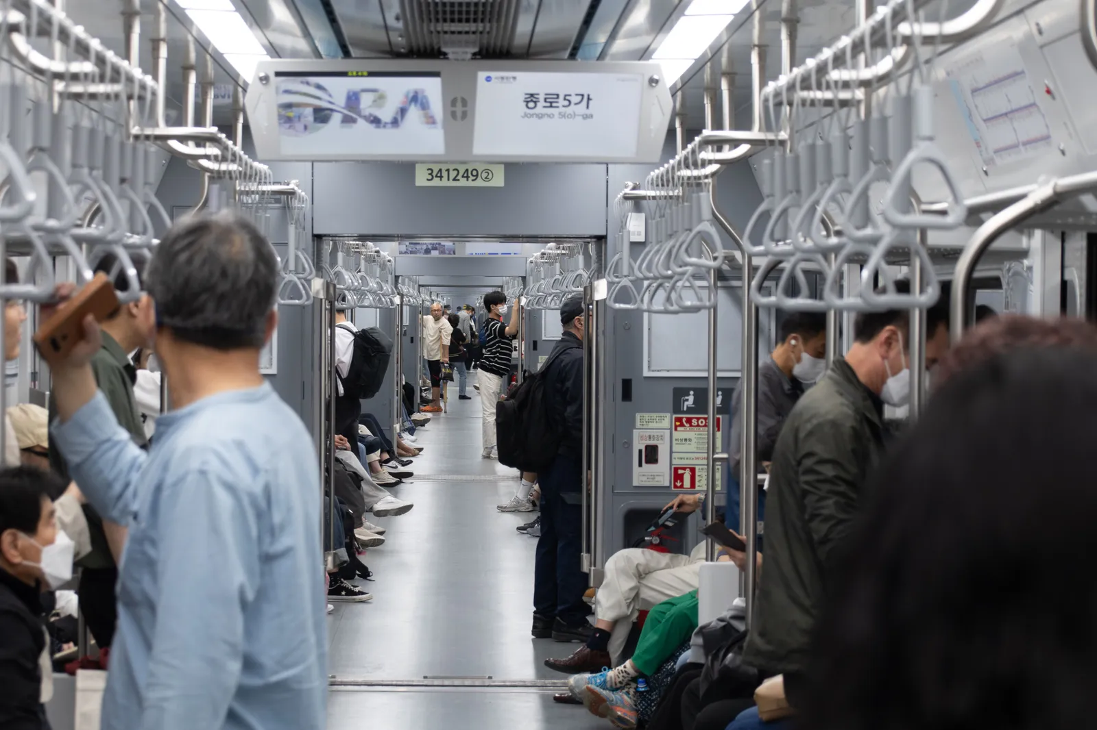 Passengers waiting on a clean, modern subway platform as a train arrives in Seoul, South Korea