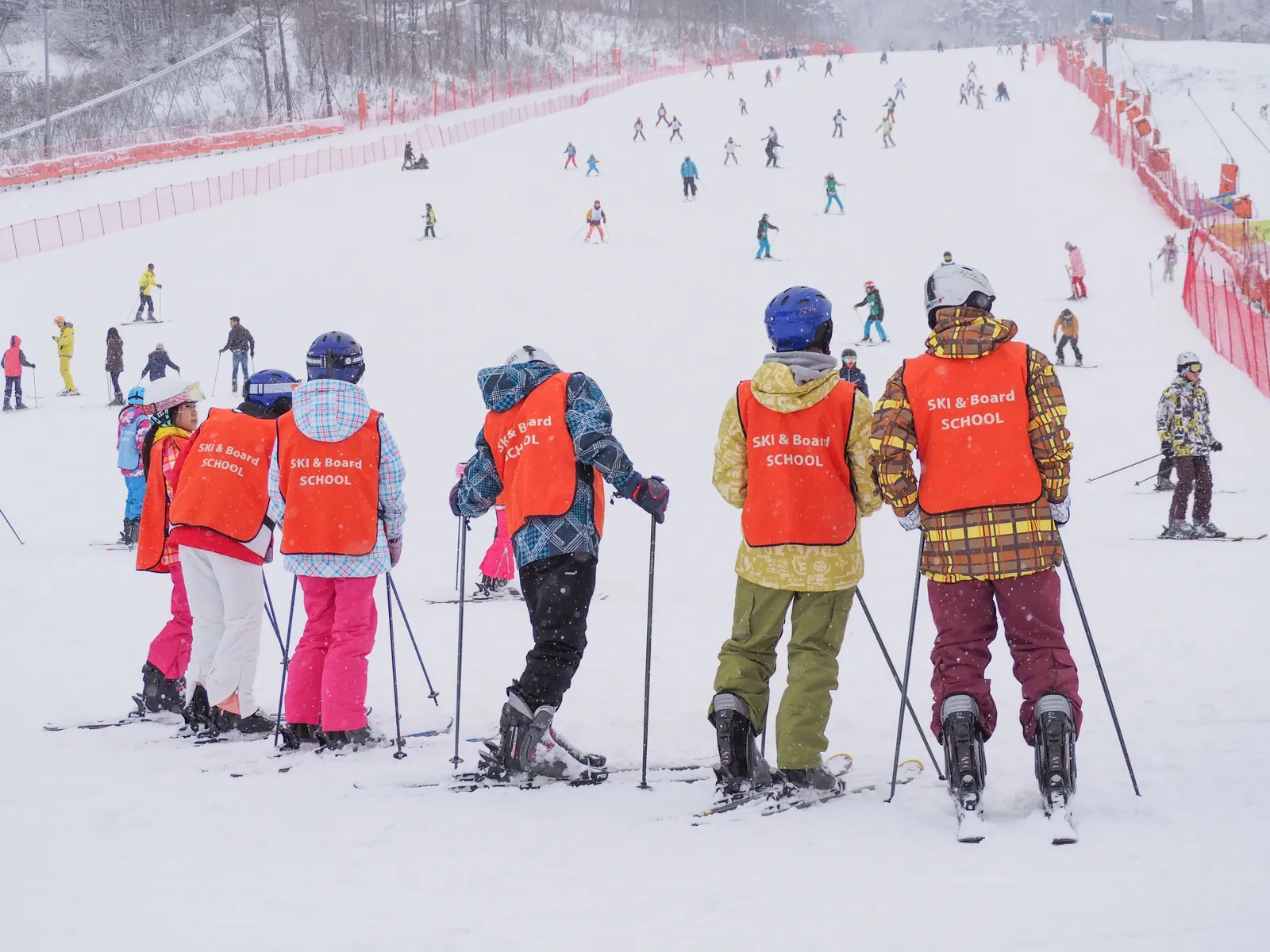 A group in ski school bibs standing on the snow at a Korean resort, South Korea