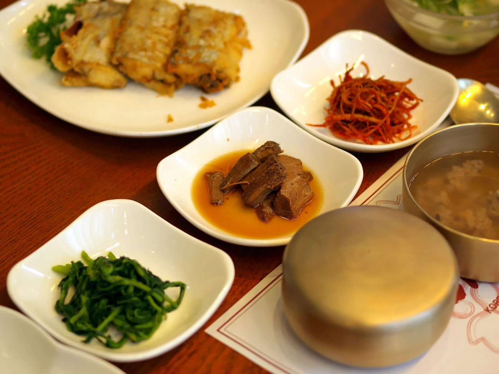A Korean table set with rice, soup and many small banchan side dishes