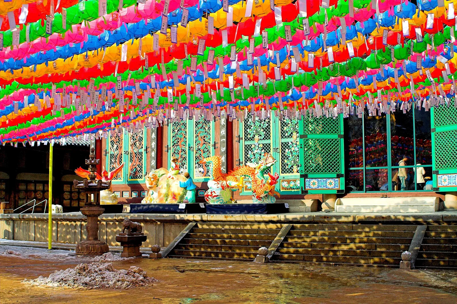 Visitors in the courtyard of Jogyesa Buddhist temple in Seoul, South Korea, on a bright day