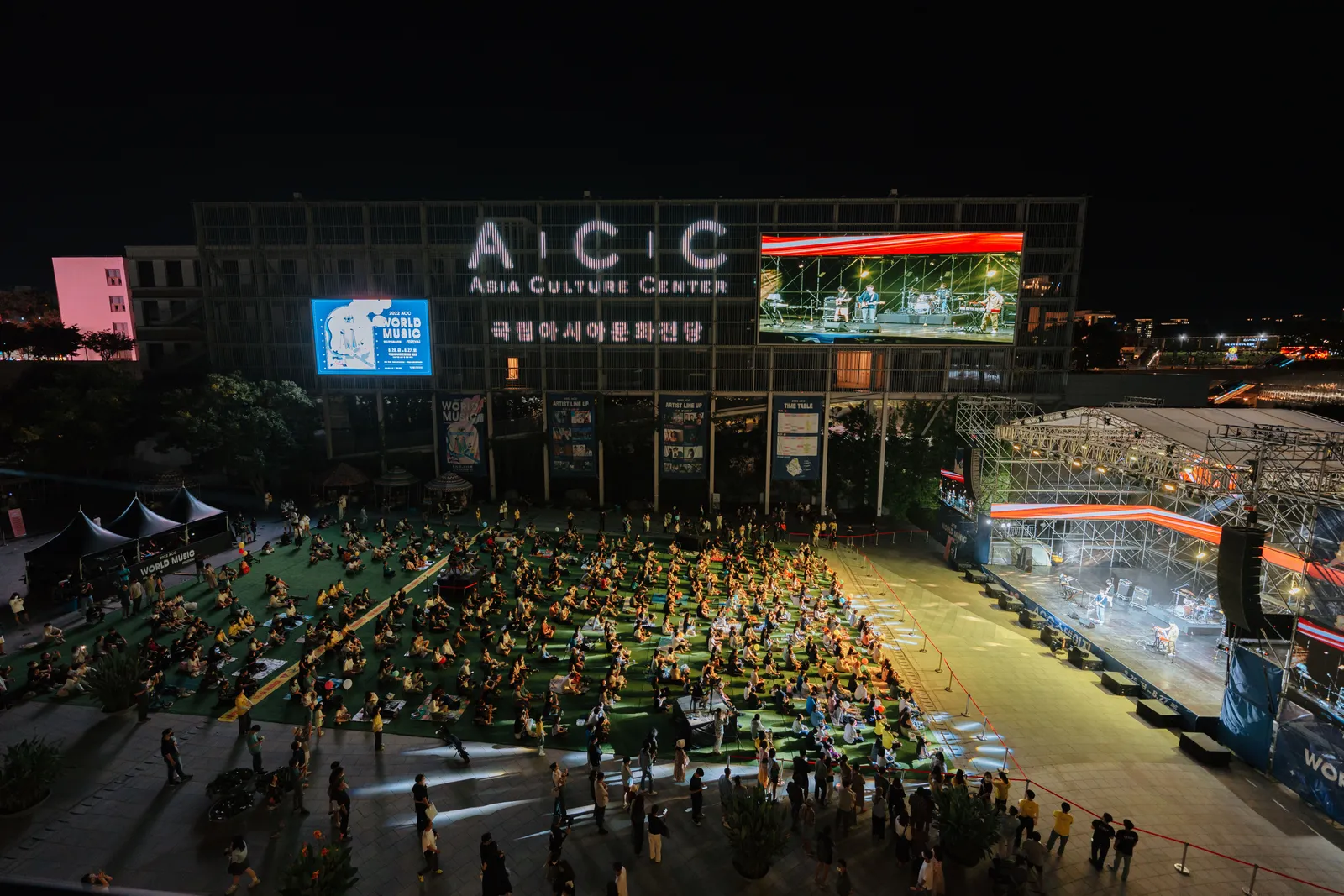 A crowd outside a lit cultural centre building at night in South Korea