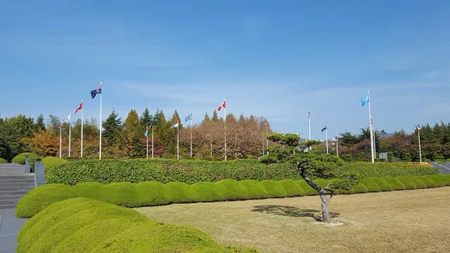 National flags flying above neatly kept green lawns