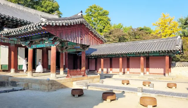 Traditional painted timber shrine halls with tiled roofs around a paved courtyard