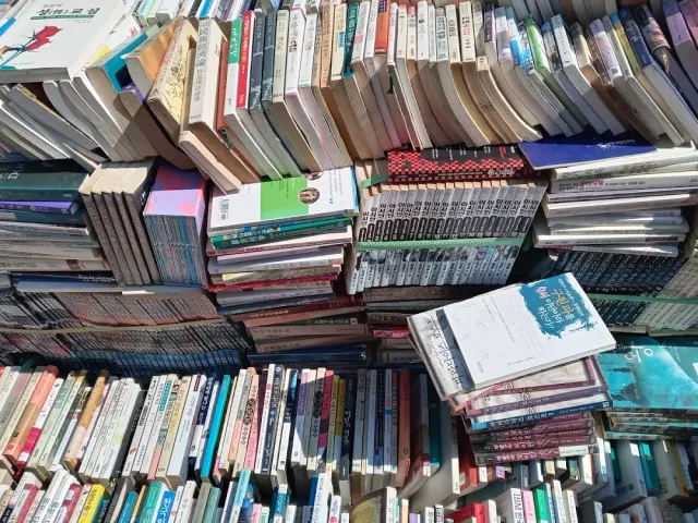 Dense piles of second hand books, some upright and some lying on one another