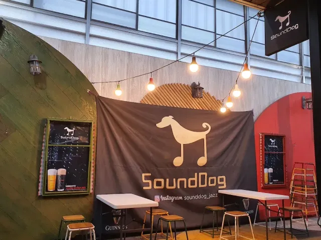 A cloth banner with a dog figure above white tables and a string of bulbs