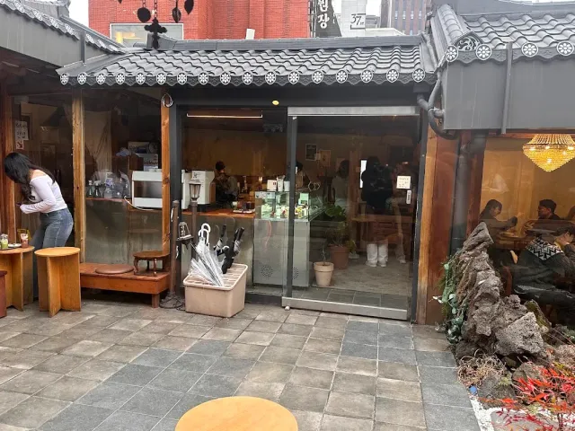 A traditional courtyard with a tiled roof, glass doors, a counter and a paved stone floor