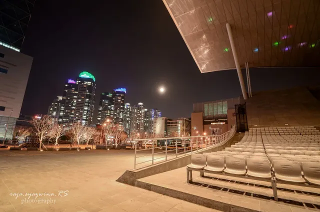 A vast metal canopy floating above a lit plaza at night