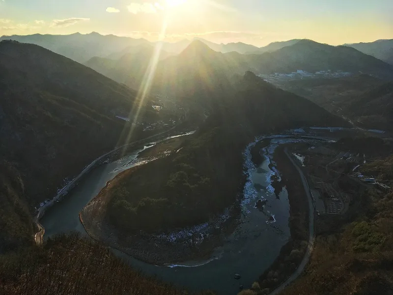 High view over a horseshoe river bend winding between mountain ridges at sunrise
