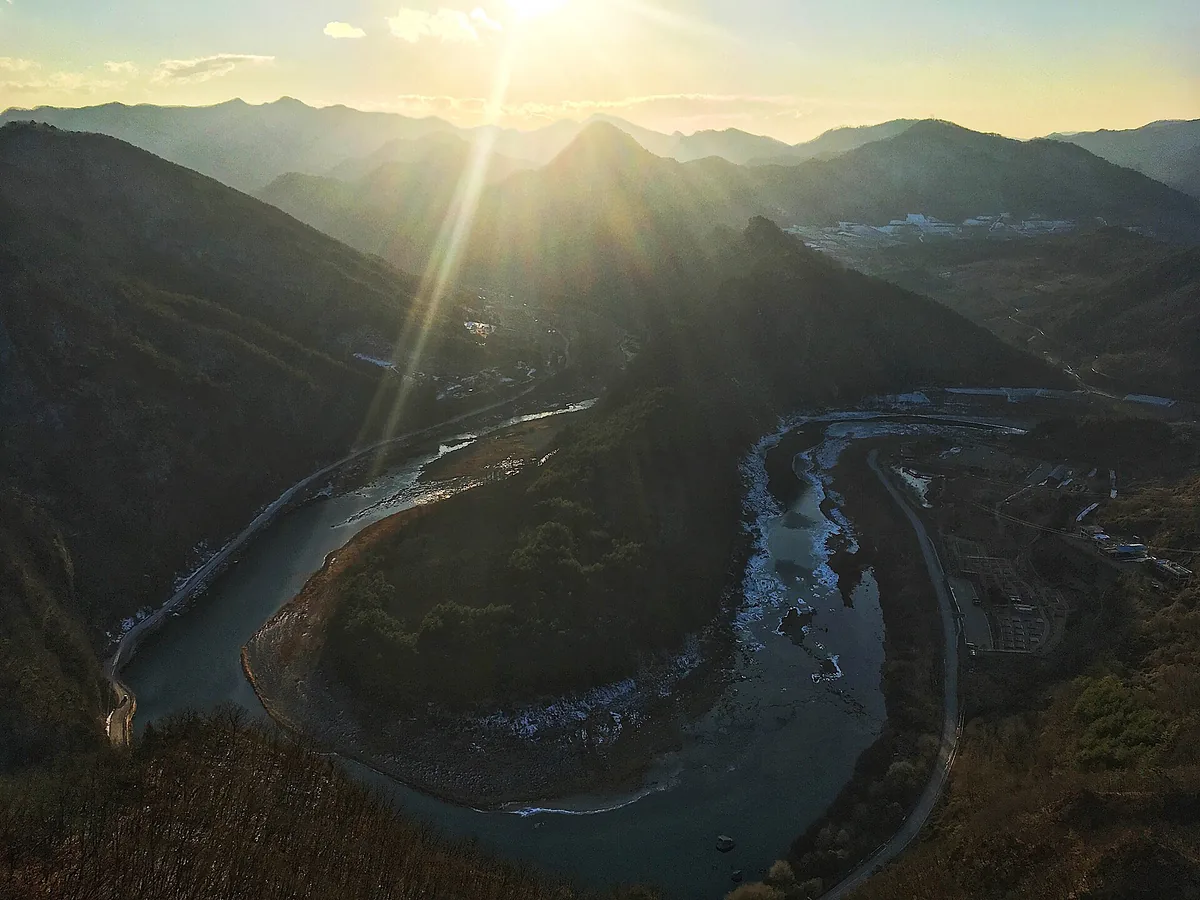 High view over a horseshoe river bend winding between mountain ridges at sunrise