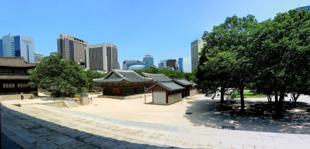 Traditional tiled roof palace halls against a backdrop of skyscrapers