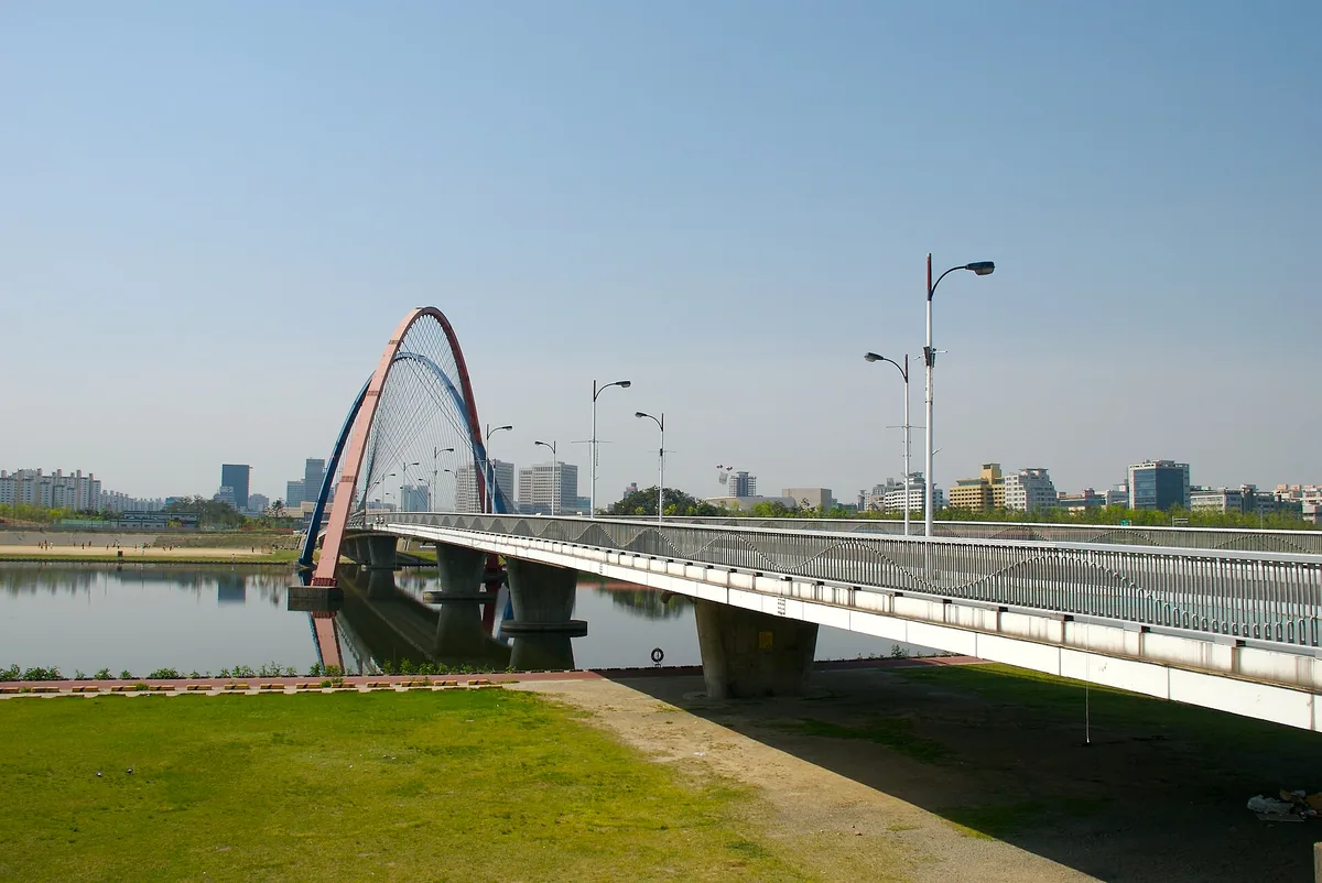 The Expo Bridge and its red steel arch over the river in Daejeon under a clear sky