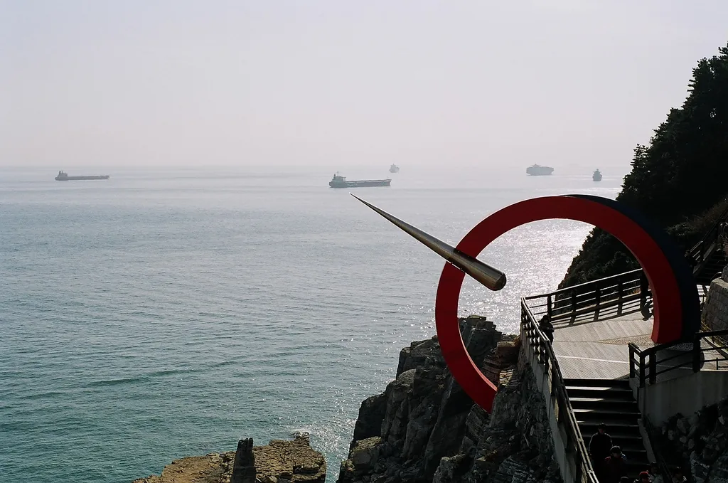 The sea cliff at Taejongdae, with the red ring sculpture and ships on the horizon