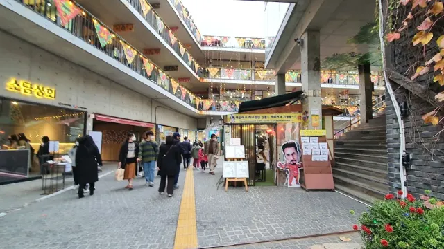 A shopping complex with tiered ramps, colorful signs and visitors in the inner courtyard