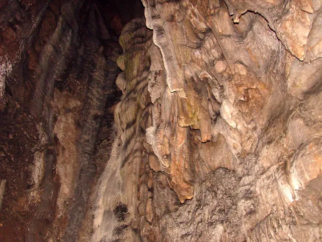 Cave walls with dripstone formations and rippled rock texture