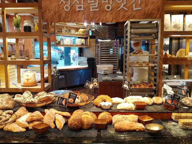 Bakery counters loaded with breads and pastries, a baking rack behind
