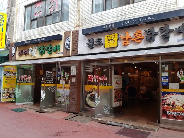 Two adjacent restaurant fronts with large signs, and diners inside
