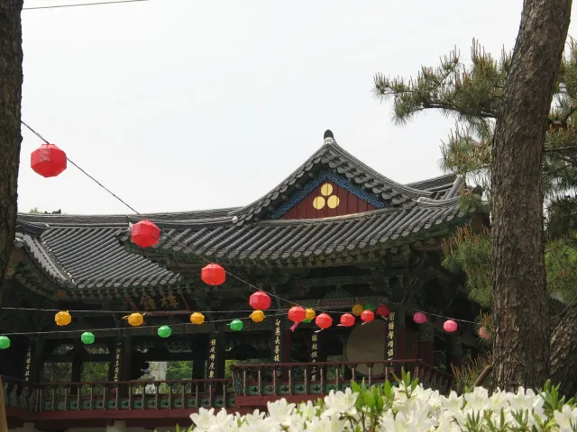 A decorated temple hall with colourful paper lanterns strung across the courtyard