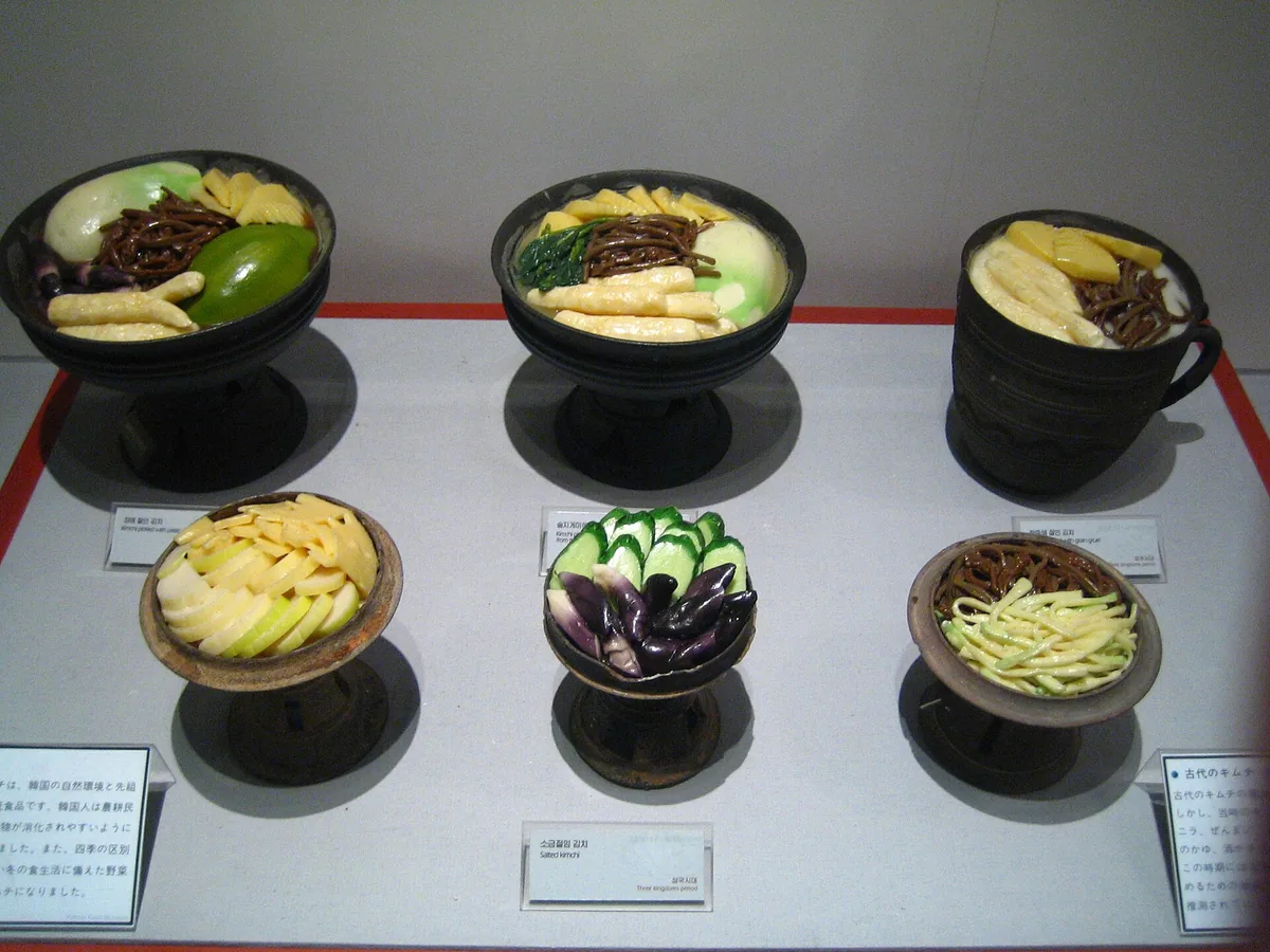 Bowls of different kimchi varieties in the museum display, each with its label
