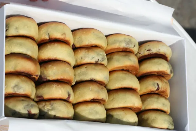 Trays of round golden pastries arranged in tight rows