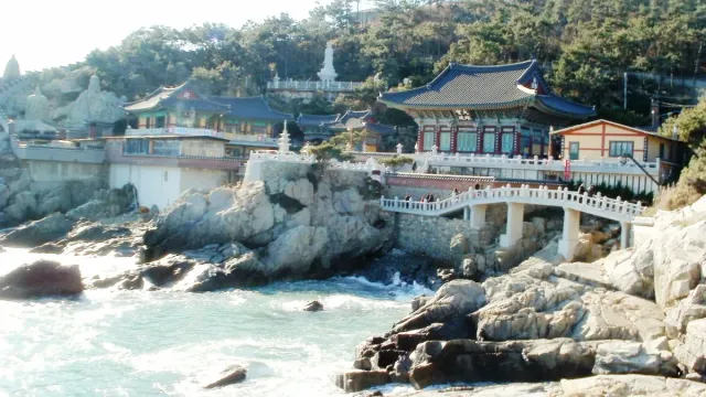 Tiled roof temple halls perched on coastal rocks above the sea