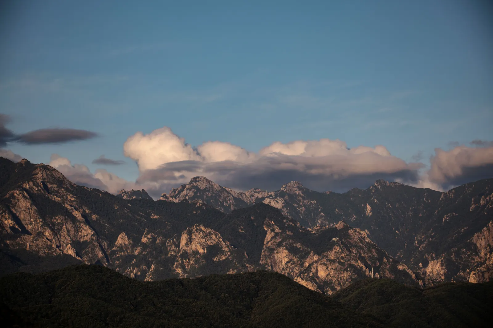 A dark mountain ridge silhouetted against clouds at dusk in Seoraksan, South Korea