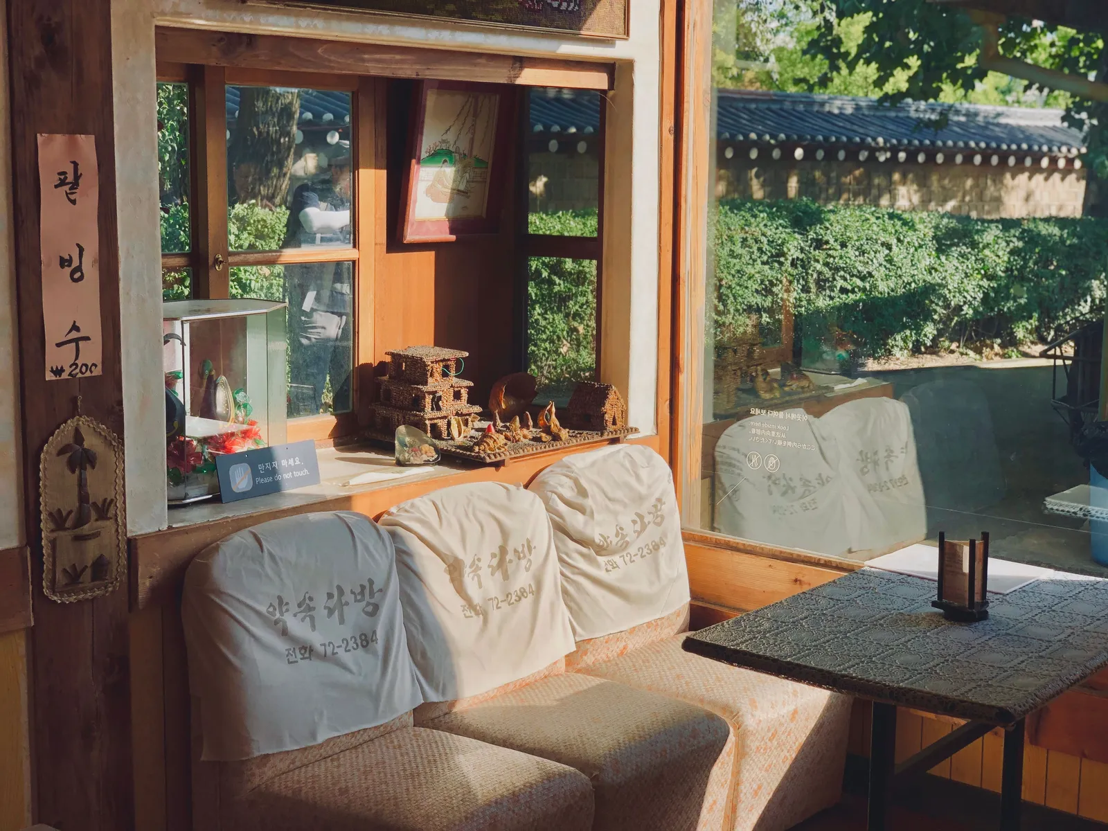 The window of a traditional style cafe looking out onto greenery in Seoul, South Korea