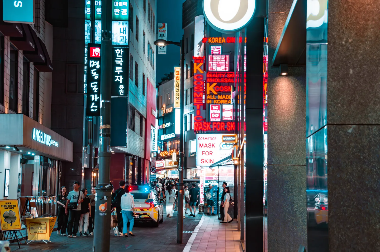 A lively night-market alley of glowing food stalls and diners on stools in central Seoul, South Korea