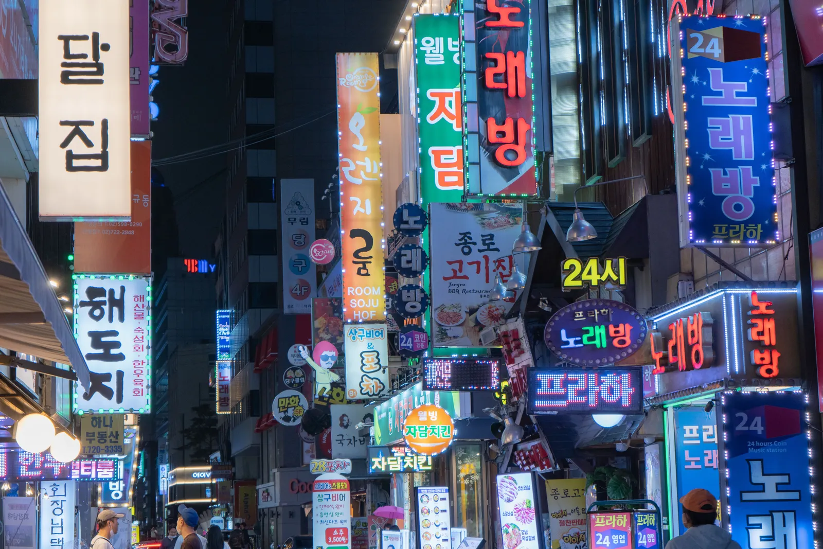 A street of illuminated shop and restaurant signs in central Seoul at night, South Korea