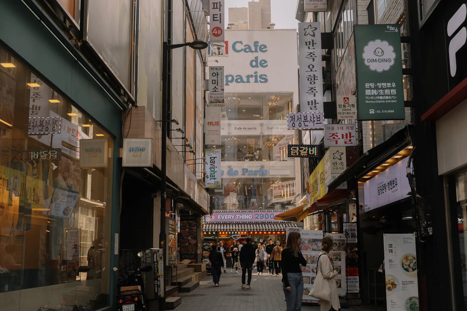 A shopping street lined with cafes and signs in central Seoul, South Korea